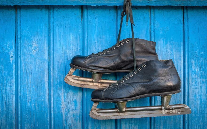 Old hockey skates hanging on a wall